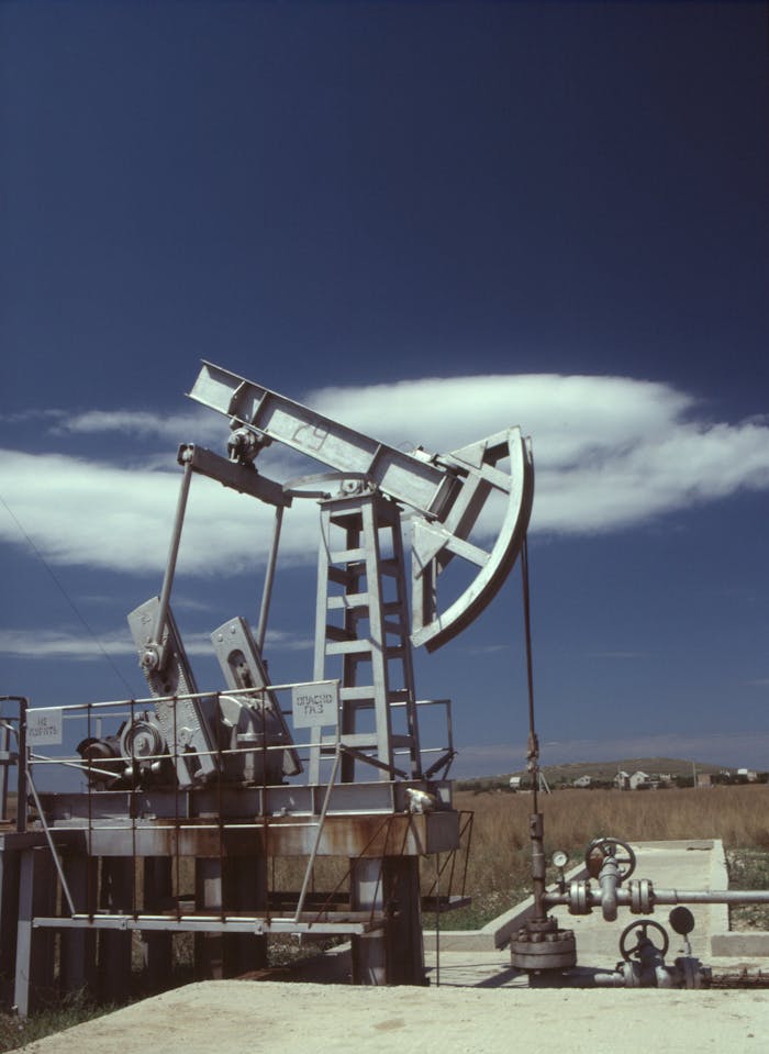 Oil pumpjack in operation against clear blue sky, highlighting industrial energy production.
